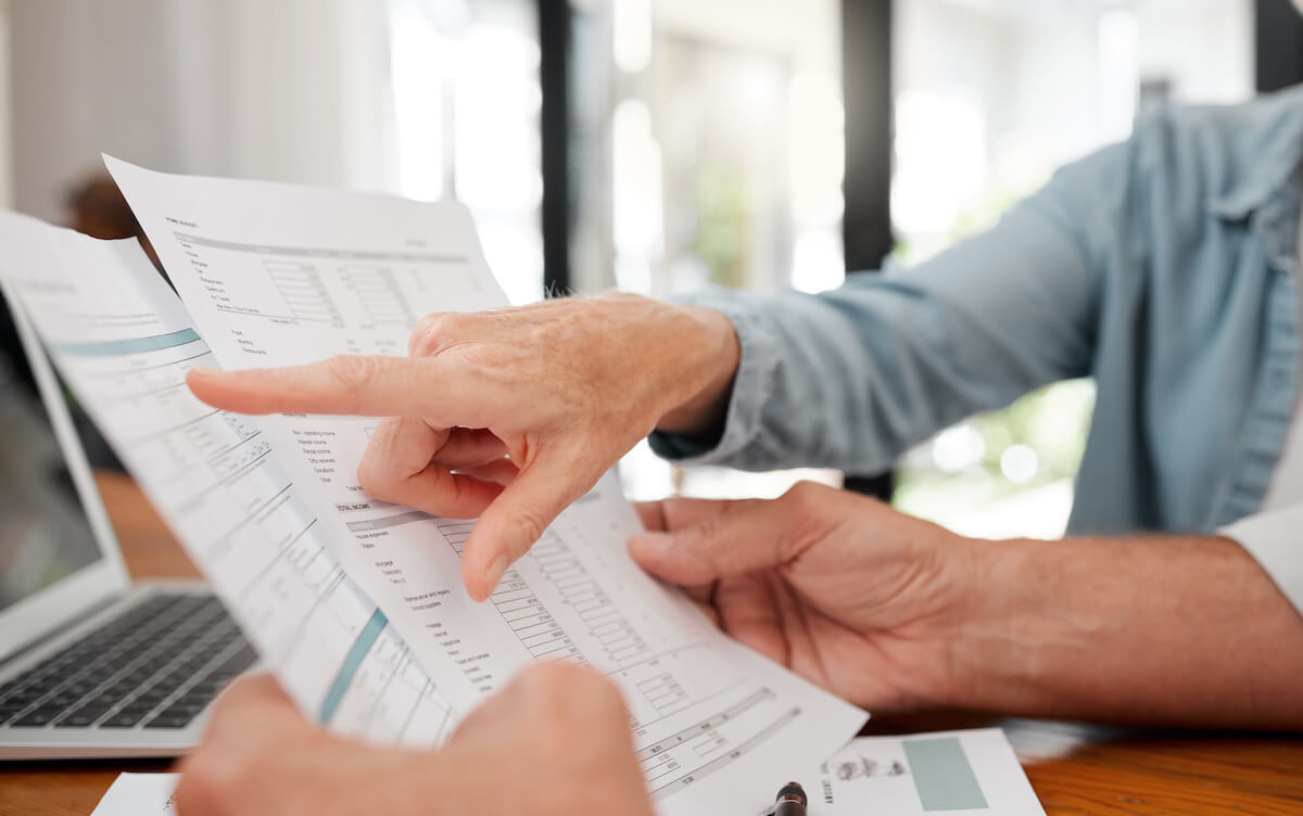 pointing at financial documents and spreadsheets